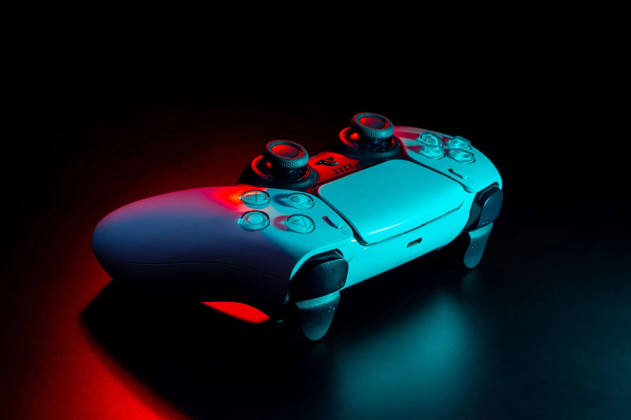 Bộ điều khiển DualSense của PS5 dưới ánh đèn neon, tượng trưng cho những buổi chơi game bị bỏ lỡ.