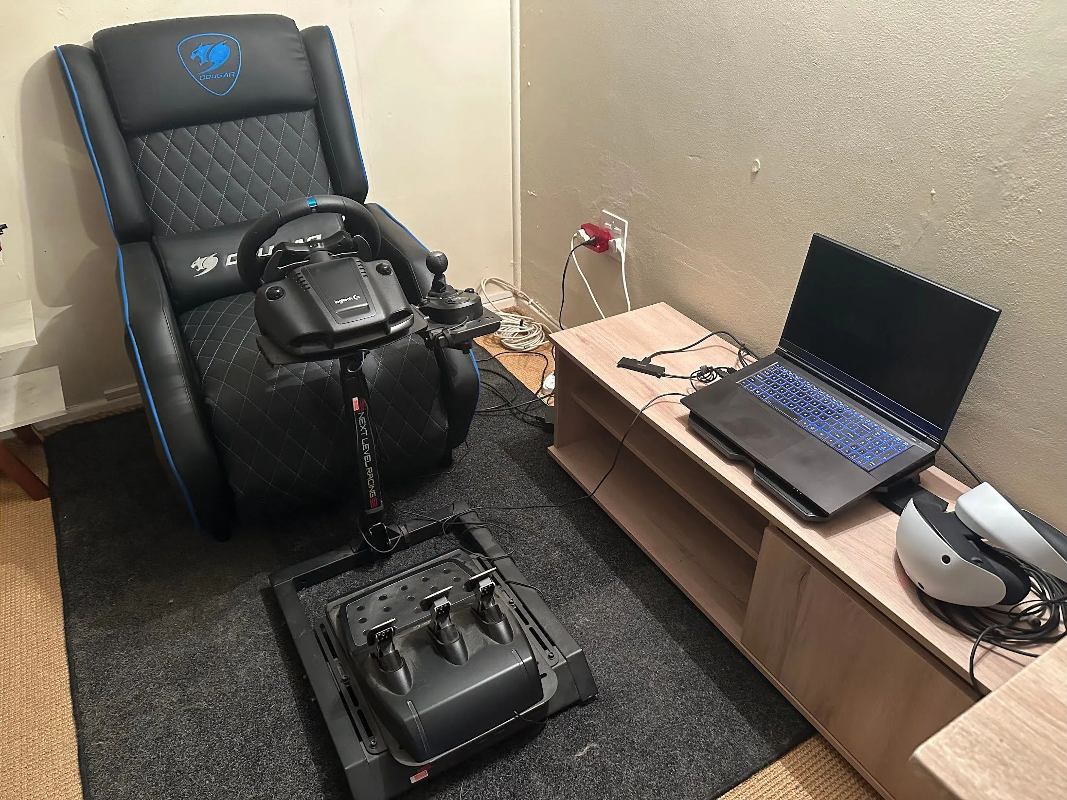 Bộ setup chơi game với laptop đặt cách xa bàn làm việc, kết nối với màn hình lớn và tai nghe VR, giúp giảm tiếng ồn hiệu quả.