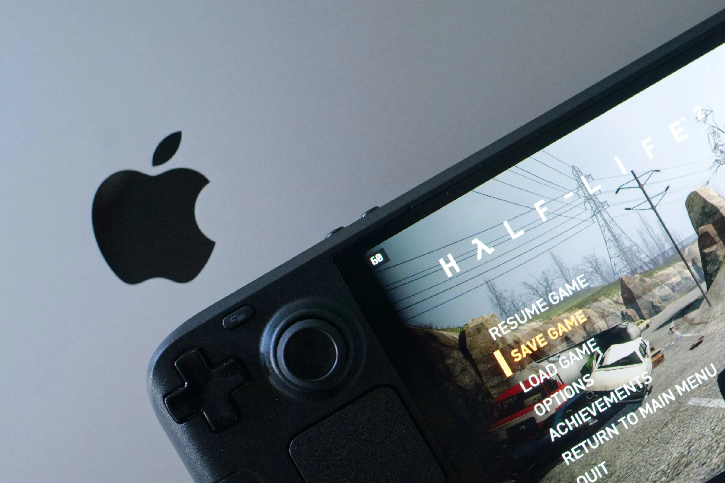 Chơi game Half-Life 2 trên Steam Deck OLED đặt cạnh MacBook Pro, minh họa sự đa dạng và tính linh hoạt của nền tảng PC trong khi Mac cũng là một máy tính.