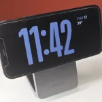 Điện thoại iPhone đặt nghiêng trên đế sạc không dây MagFlow Qi2.
