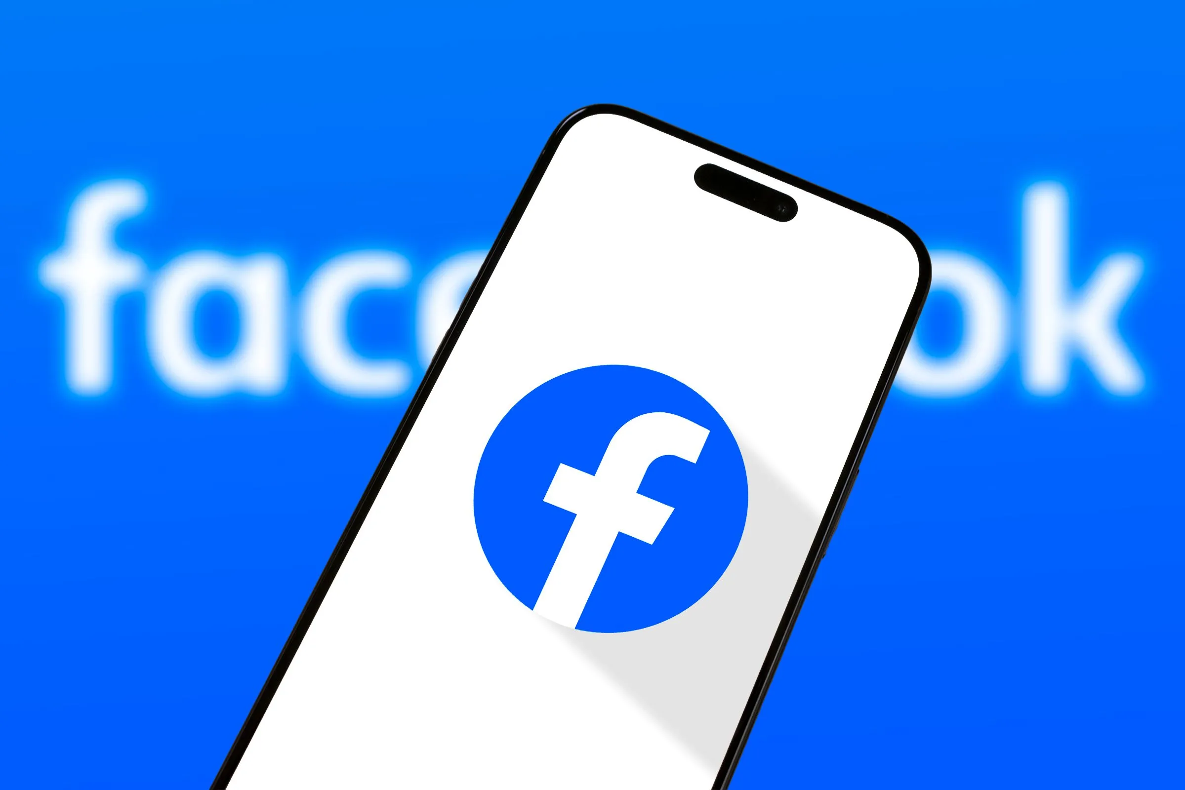 Điện thoại thông minh hiển thị logo Facebook trên màn hình, tượng trưng cho kết nối cộng đồng và cập nhật tin tức