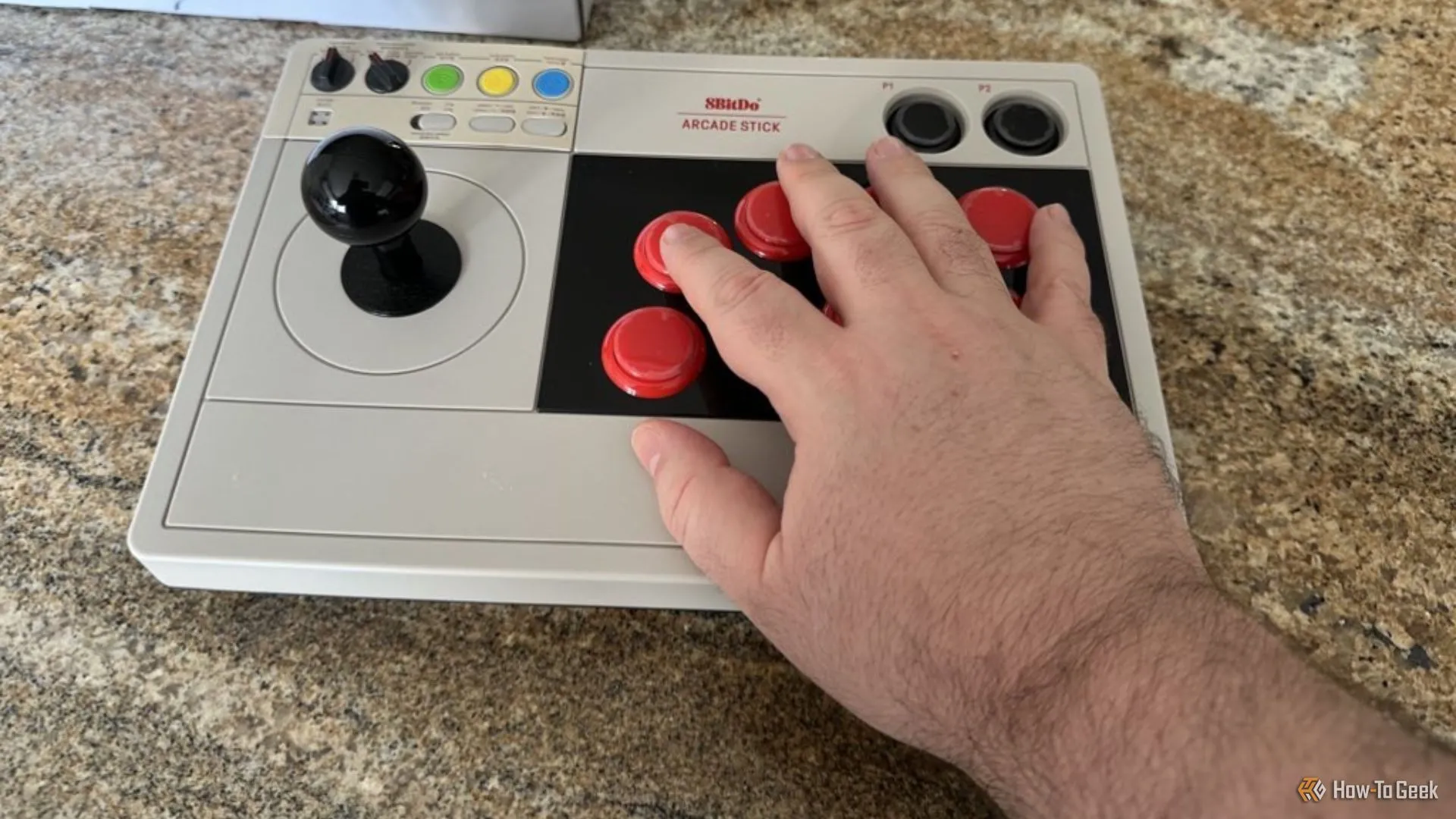 Góc nhìn cận cảnh tay cầm Arcade 8BitDo cho Switch với bàn tay làm thước đo