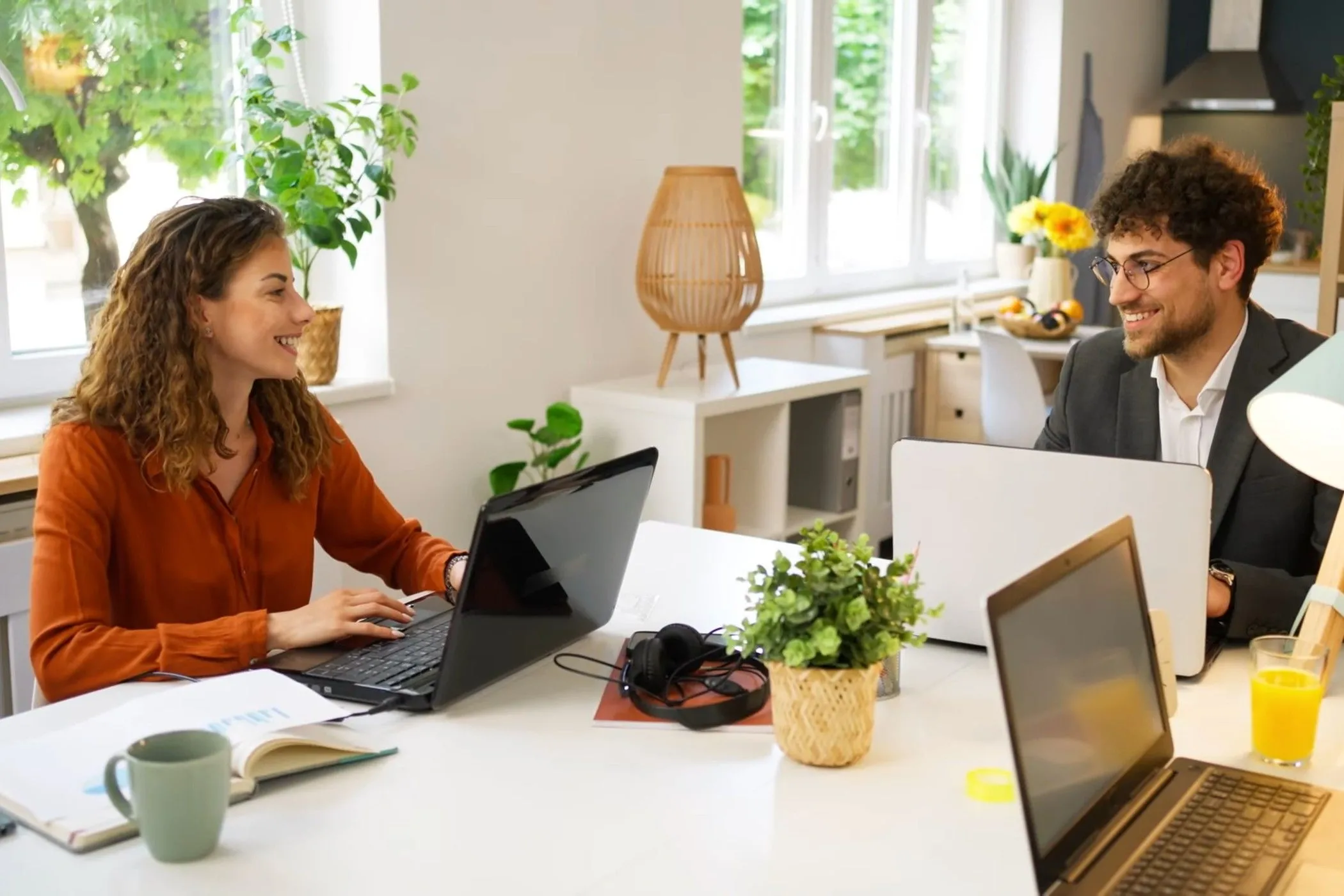 Hai người đang sử dụng tai nghe Google Adaptive Audio trong không gian làm việc chung, thể hiện sự tập trung và tăng cường năng suất