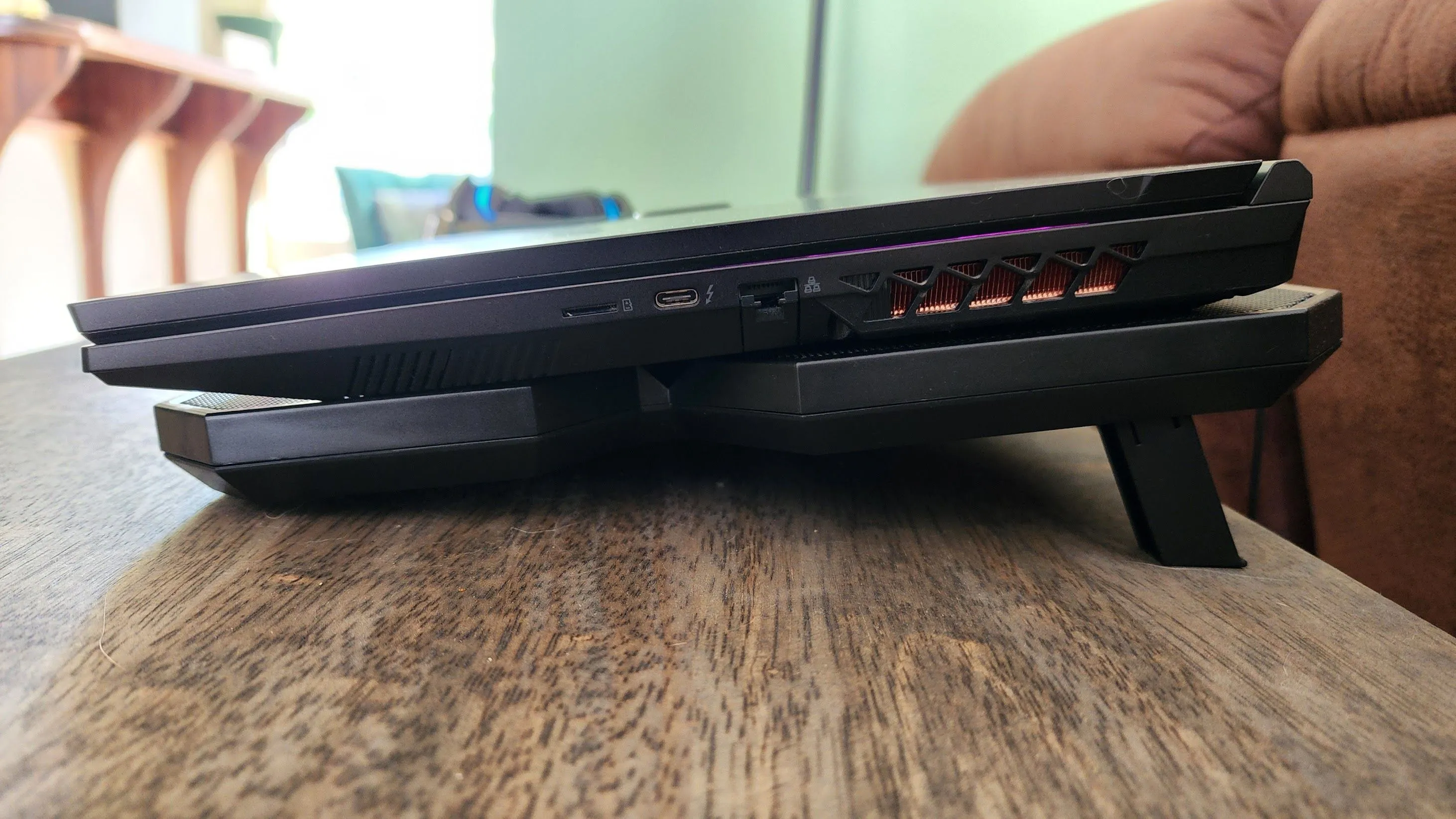 Laptop gaming đặt trên đế tản nhiệt đang hoạt động giúp tăng luồng khí và giảm nhiệt độ.