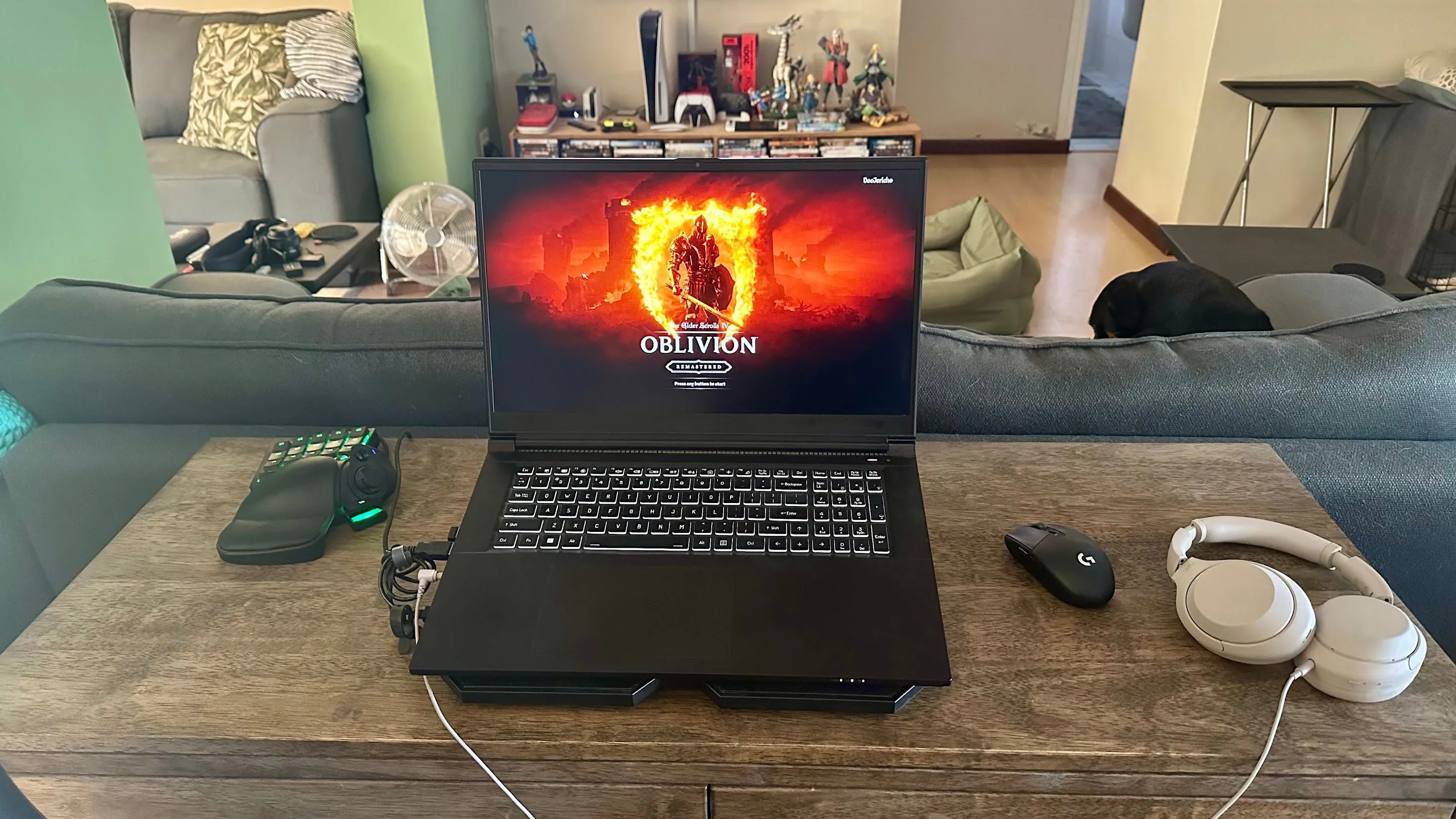 Laptop gaming đặt trên đế tản nhiệt, kèm bàn phím gaming một tay Razer Tartarus bên trái giúp tối ưu tư thế chơi game.
