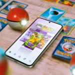 Màn hình điện thoại chơi Pokémon TCG Pocket, xung quanh là thẻ bài và Poké Ball