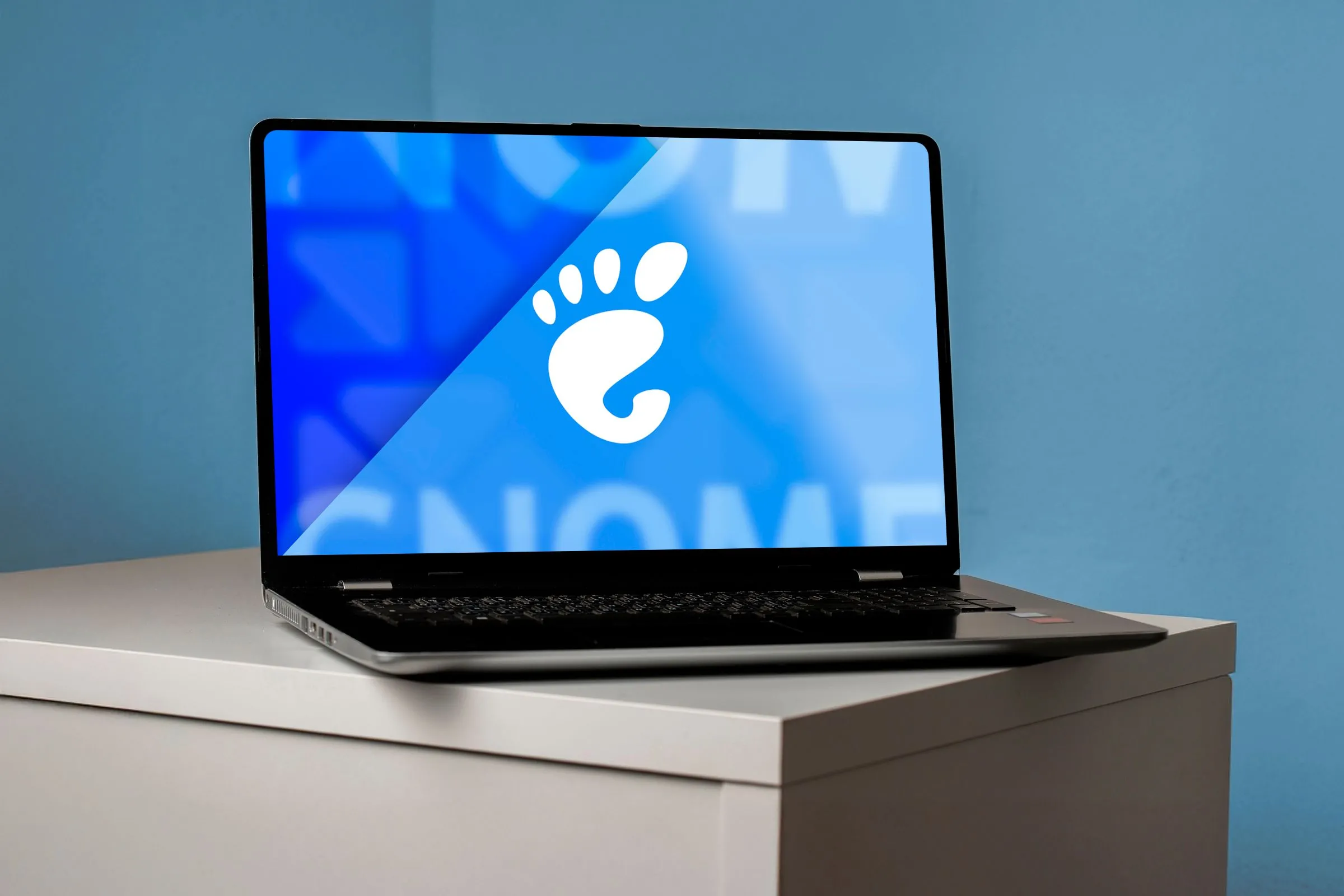 Màn hình laptop hiển thị logo GNOME trên nền tối, đại diện cho môi trường desktop Linux.