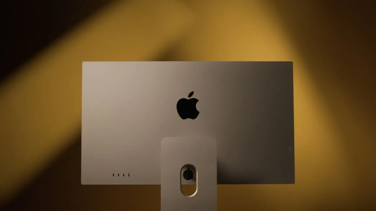 Mặt sau của màn hình Apple Studio Display trên nền vàng, nhấn mạnh nhu cầu về một màn hình Apple mới với tần số quét cao hơn để tối ưu trải nghiệm Mac chơi game.