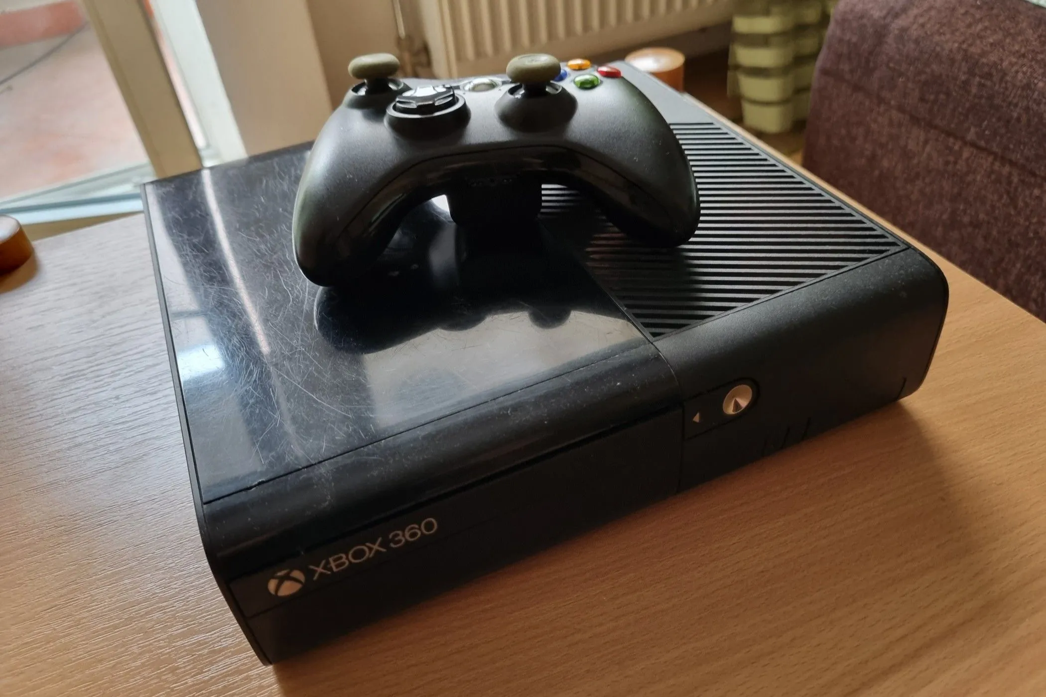 Máy chơi game Xbox 360 đã qua sử dụng màu đen với tay cầm đặt phía trên