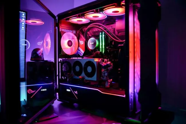 Máy tính chơi game mở nắp bên hông, lộ rõ đèn RGB nội thất sáng rực, thể hiện niềm tự hào sau khi tự lắp ráp.