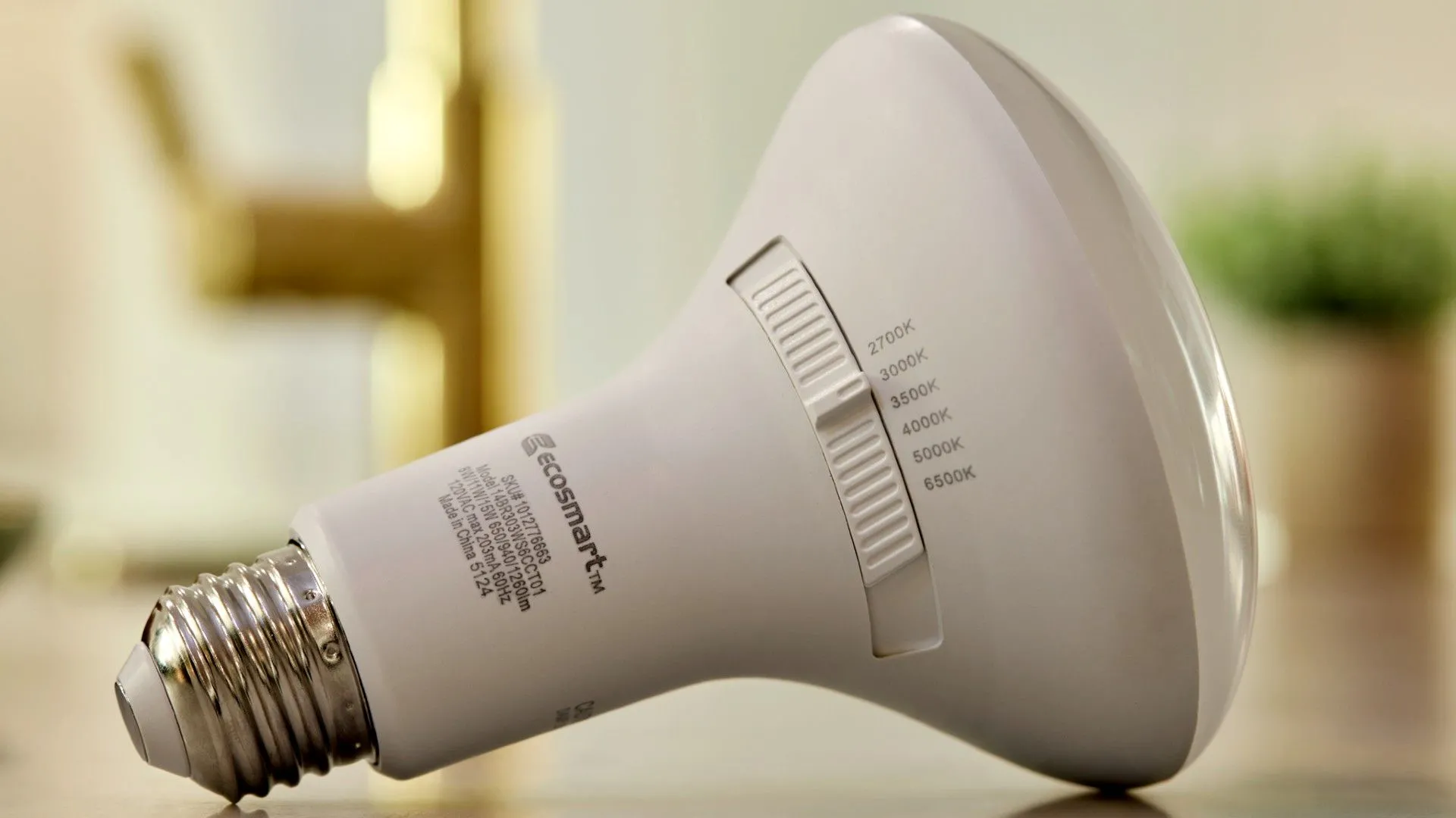 Một bóng đèn thông minh EcoSmart đang phát sáng với nhiều chế độ màu khác nhau, thể hiện tính năng Universal Select Light Bulb