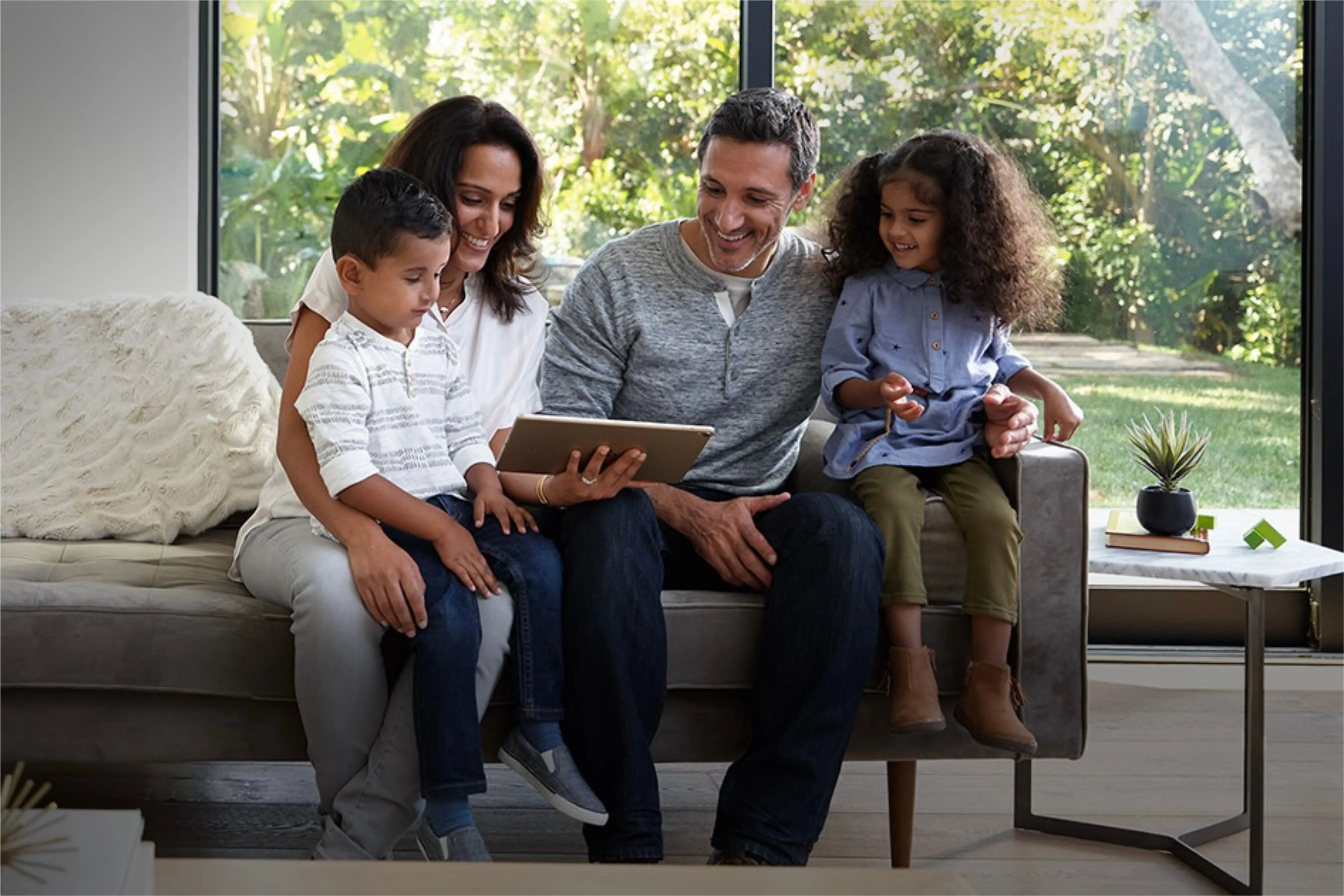 Một gia đình đang cùng nhau sử dụng iPad cơ bản trên ghế sofa, thể hiện tính linh hoạt và phù hợp với nhu cầu giải trí, học tập của người dùng phổ thông.