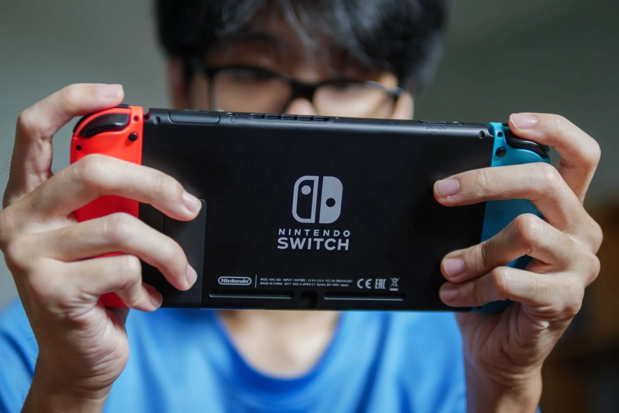 Một người đàn ông trải nghiệm chơi game trên Nintendo Switch ở chế độ cầm tay, thể hiện sự linh hoạt của console.