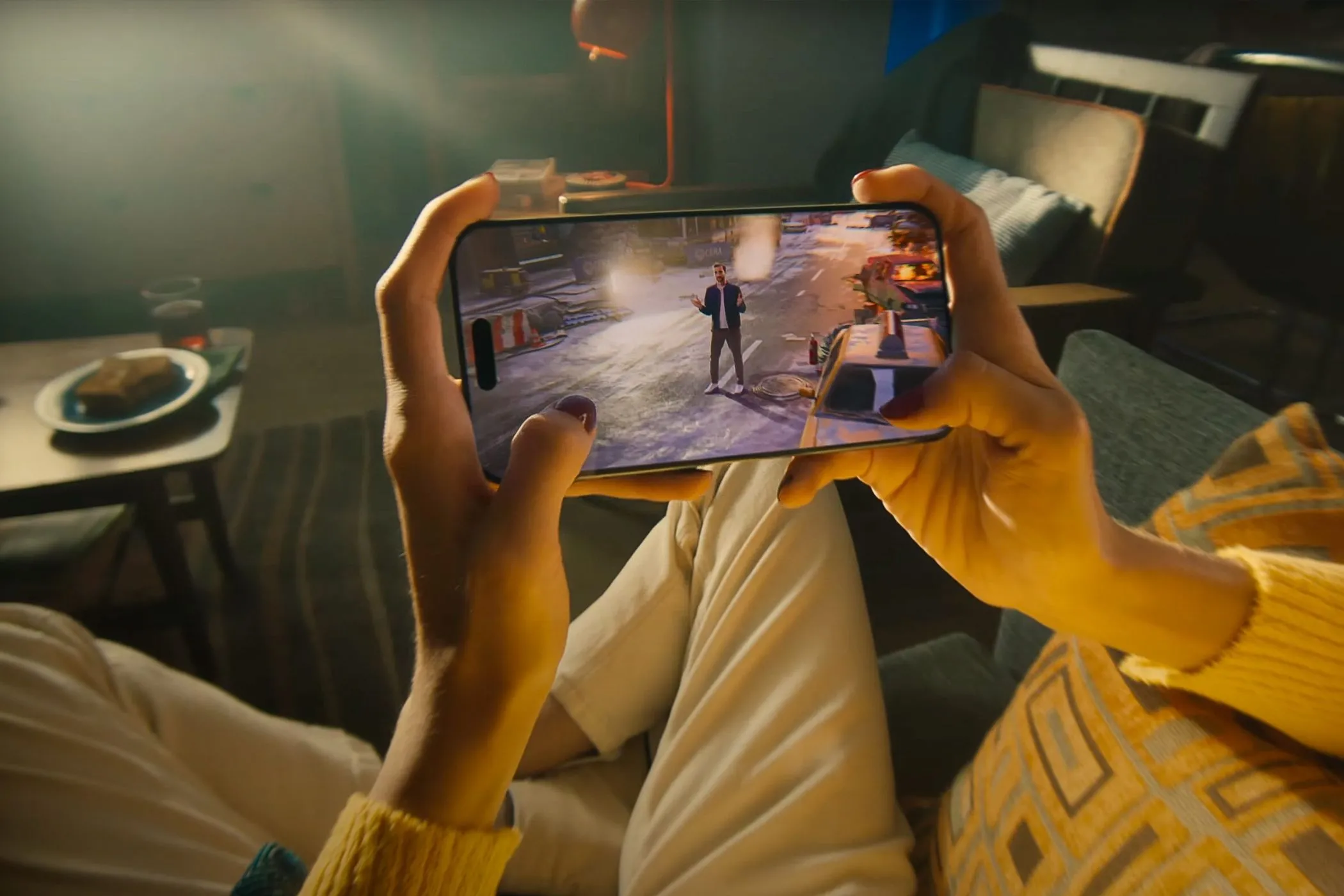 Một người đang cầm iPhone 15 Pro chơi game, minh họa việc tìm kiếm hoạt động thay thế cho doomscrolling.