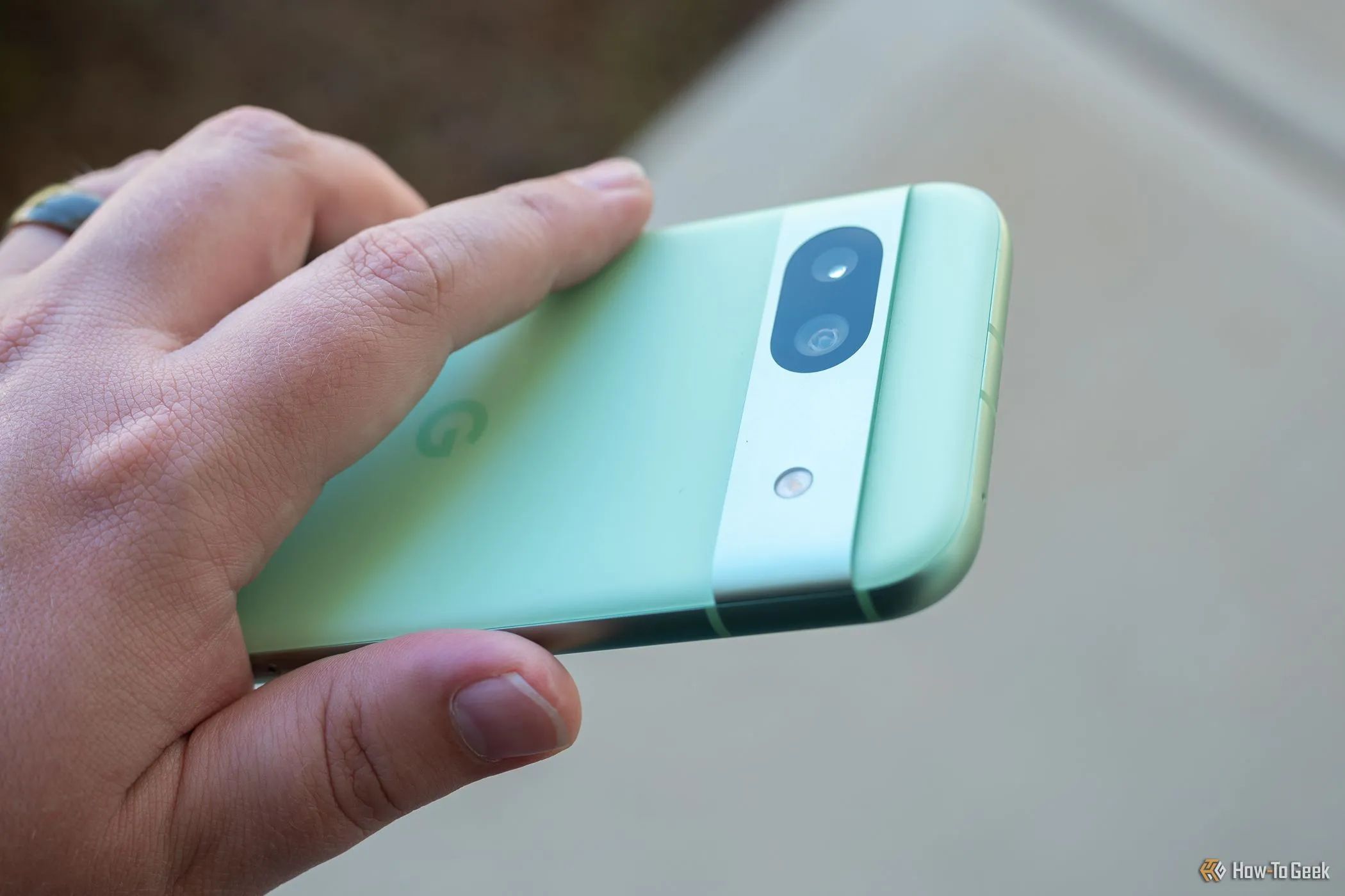 Người đang cầm chiếc Google Pixel 8a, cho thấy cụm camera sau