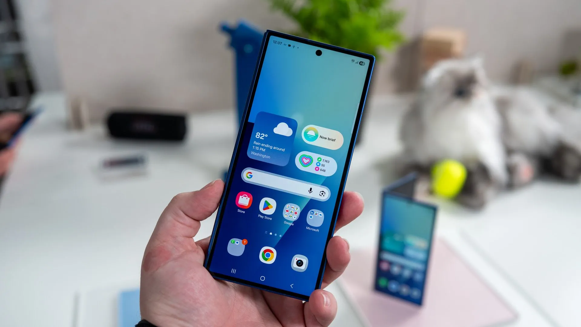 Người dùng cầm Galaxy Z Fold 7 khi gập lại với màn hình phụ đang bật