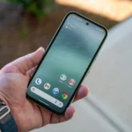 Người dùng cầm Google Pixel 8a hiển thị màn hình chính và viền máy