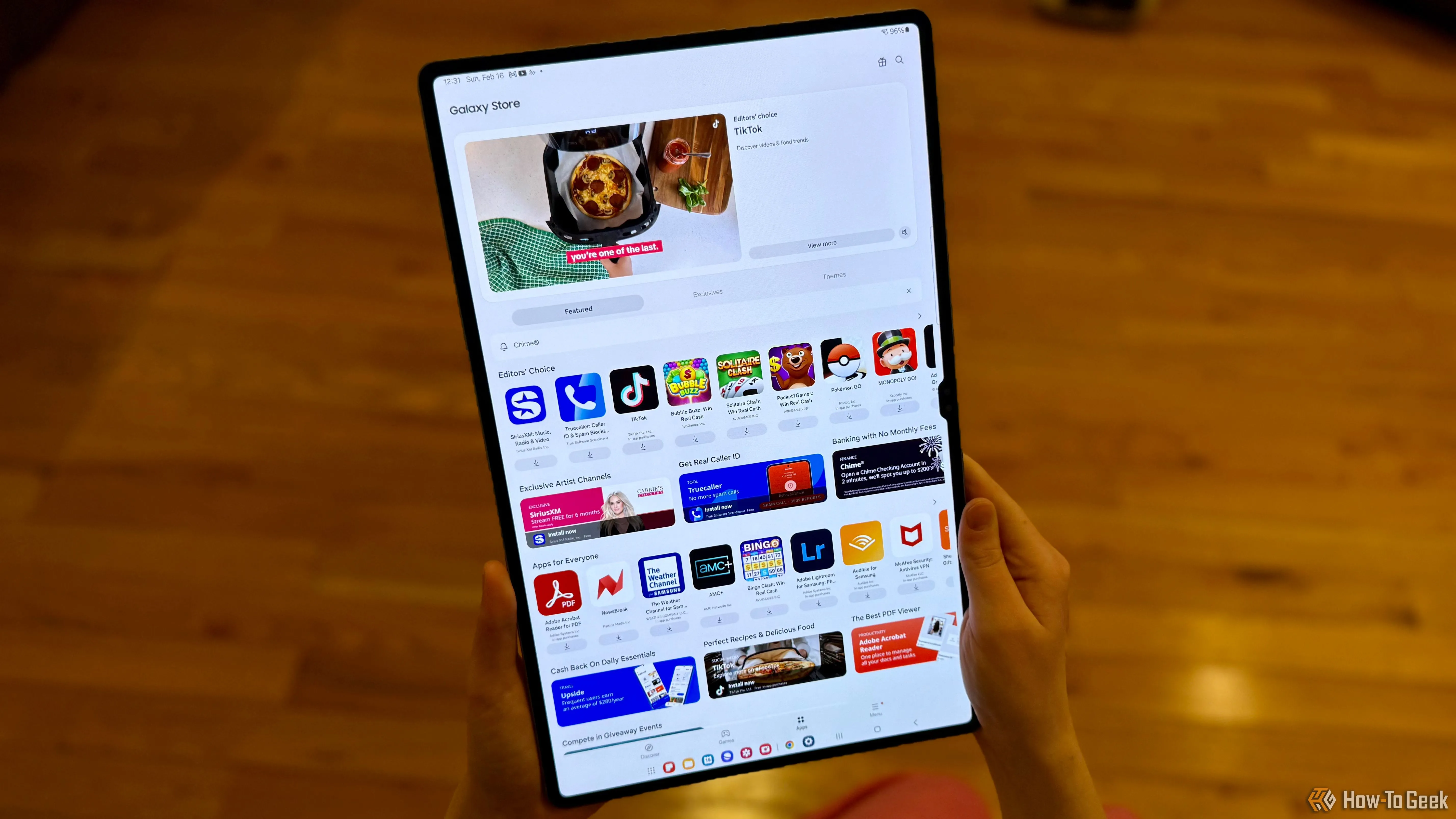 Người dùng đang cầm máy tính bảng Samsung Galaxy Tab S10 Ultra hiển thị ứng dụng Galaxy Store
