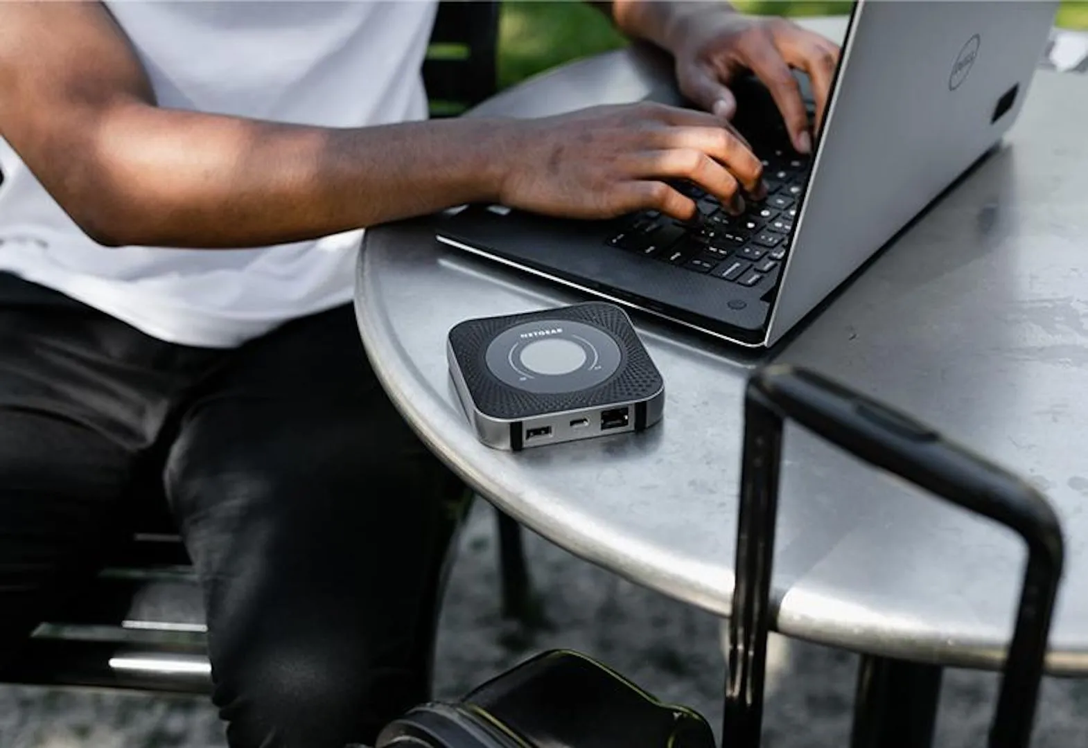 Router di động Nighthawk M1 4G LTE trên bàn cafe cạnh laptop, minh họa vị trí đặt router tối ưu