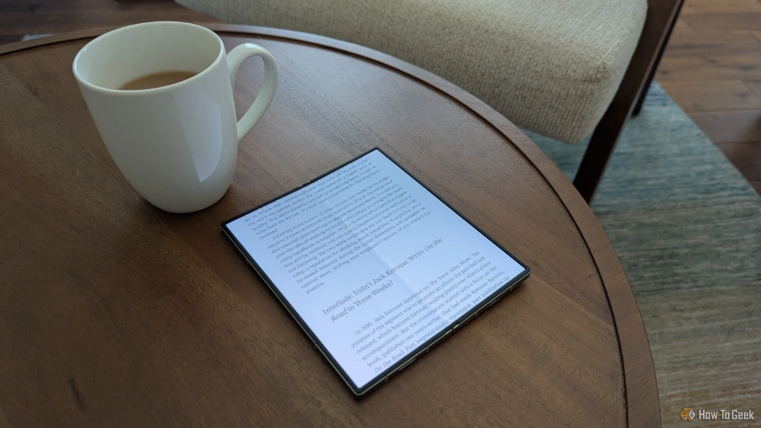 Sách điện tử hiển thị trên màn hình gập của Galaxy Z Fold 6 đặt cạnh cốc trà