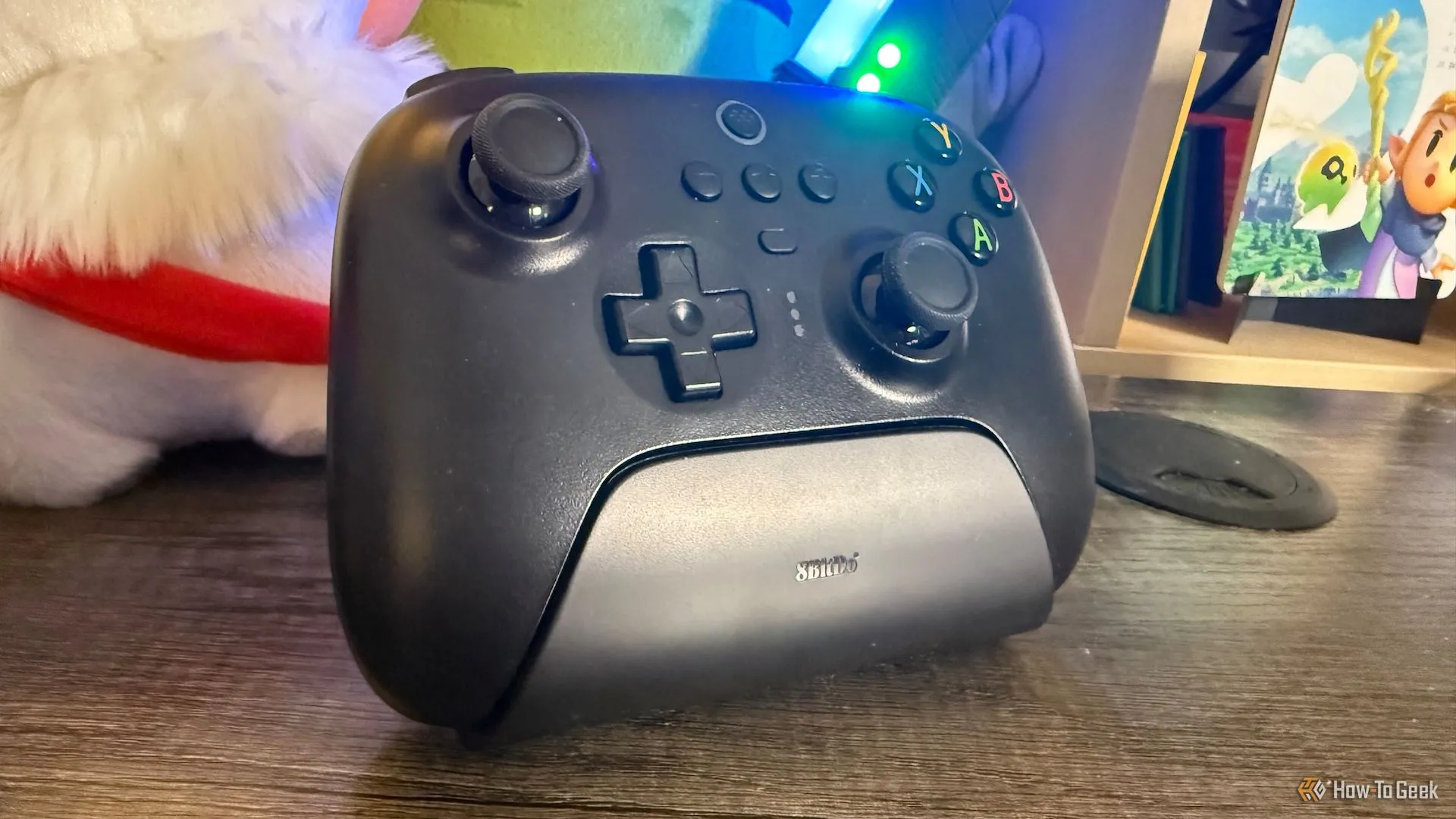Tay cầm 8BitDo Ultimate 2.4G đặt trên dock sạc của nó, hiển thị các nút bấm và thiết kế tổng thể.