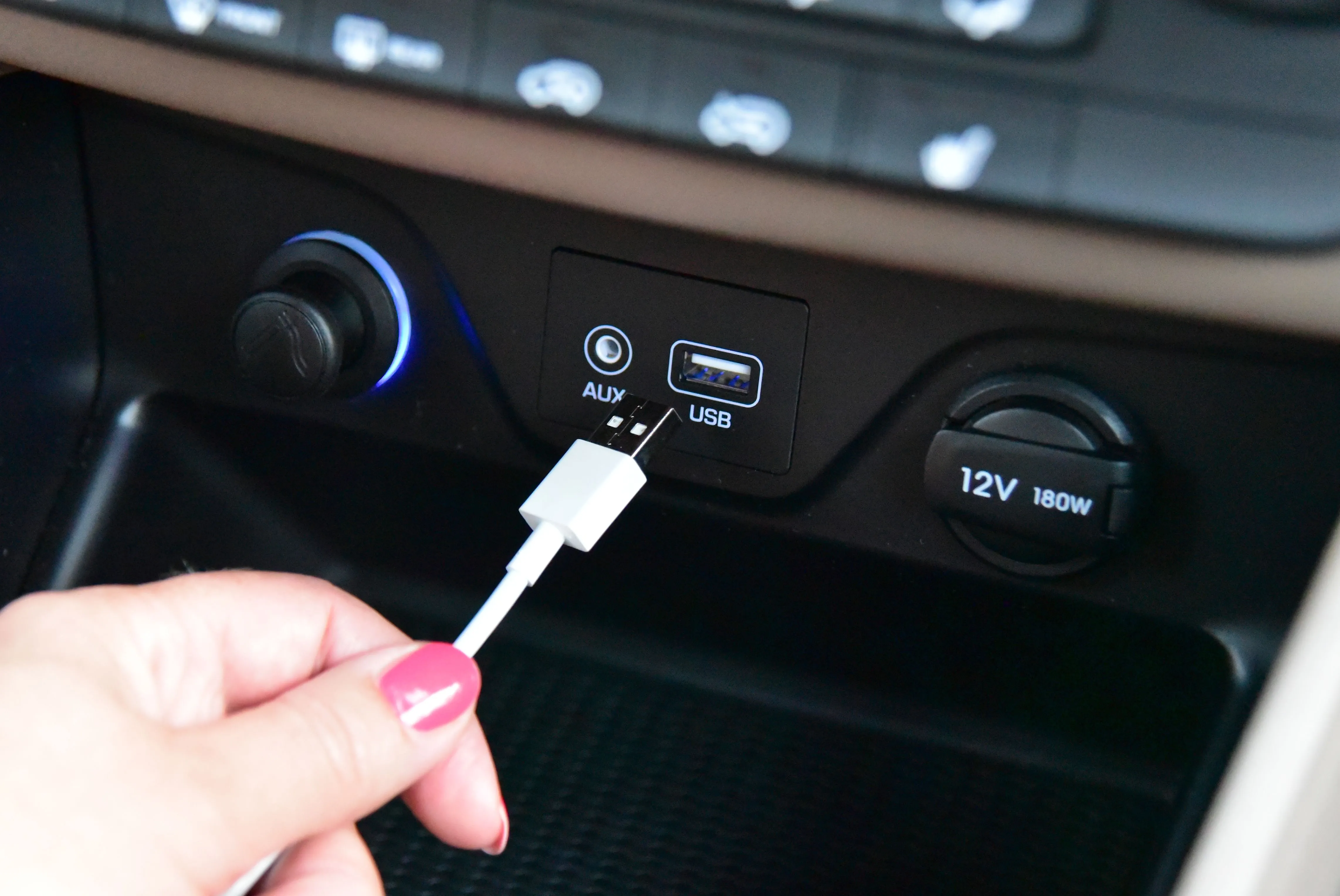 Tay cắm cáp USB-A vào cổng sạc trên bảng điều khiển ô tô, minh họa sự bất tiện của chuẩn cũ